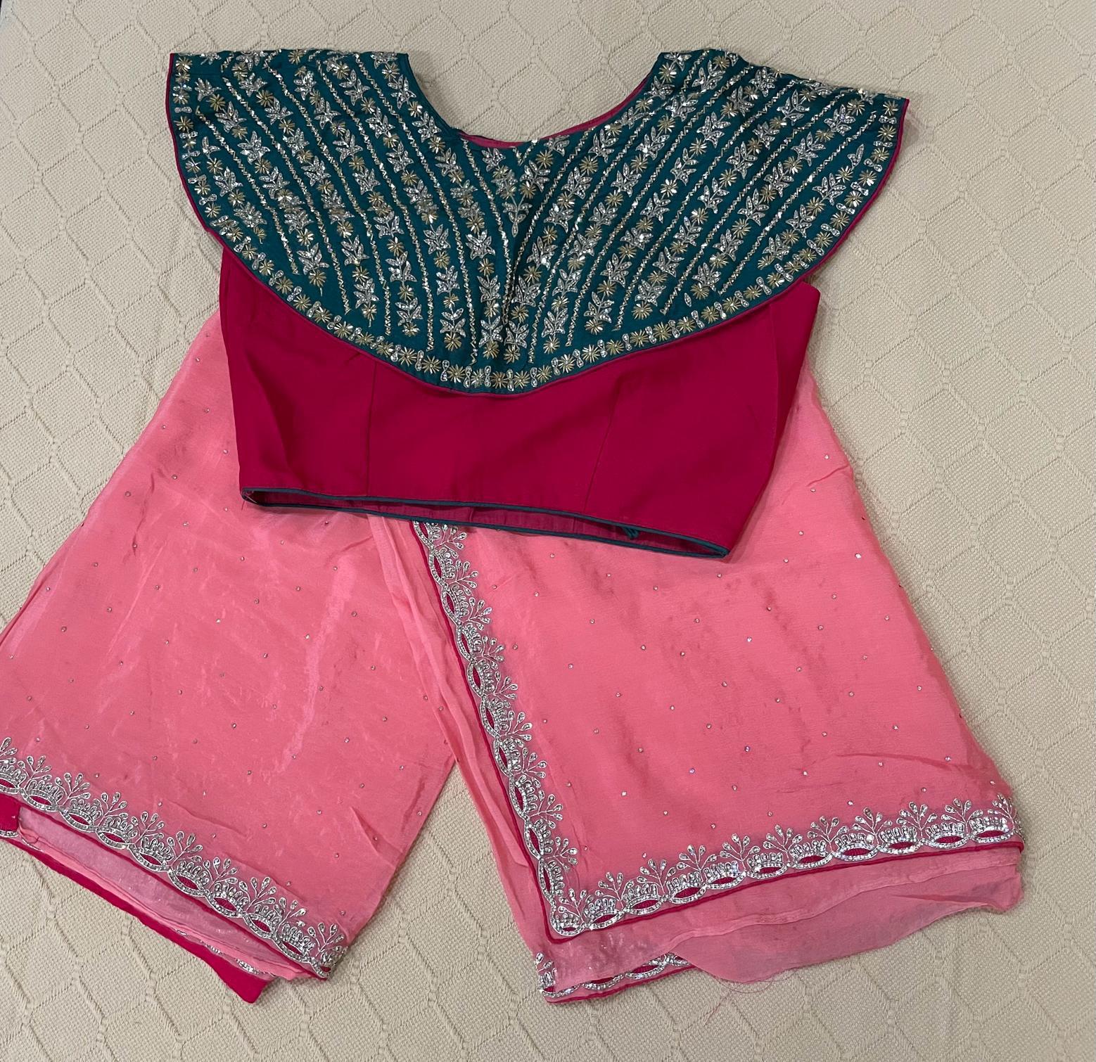 Premium Fancy Saree in peachish pink color with a dark red and green embellished high fashion blouse